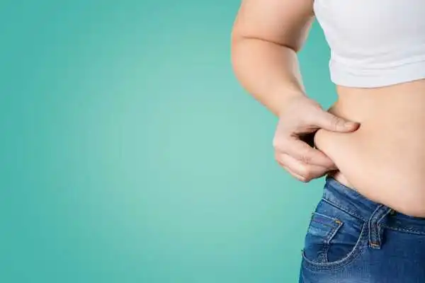 Image of woman pinching her love handles to show weight gain Aylesbury